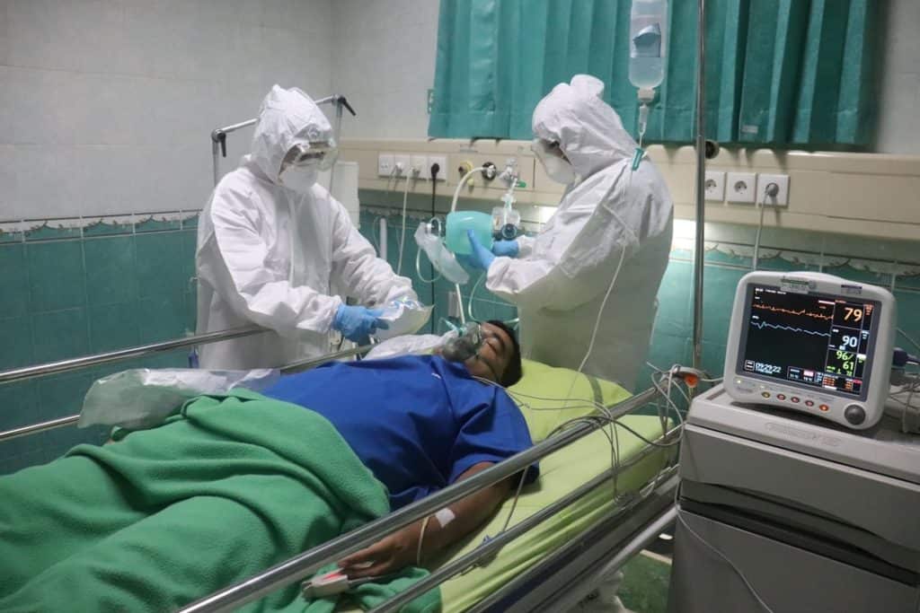 Nurses treating patient while wearing PPE