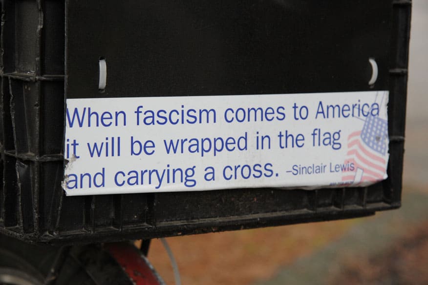 Closeup of bumper sticker with famous Sinclair Lewis line "When fascism comes to America it will be wrapped in the flag and carrying a cross"