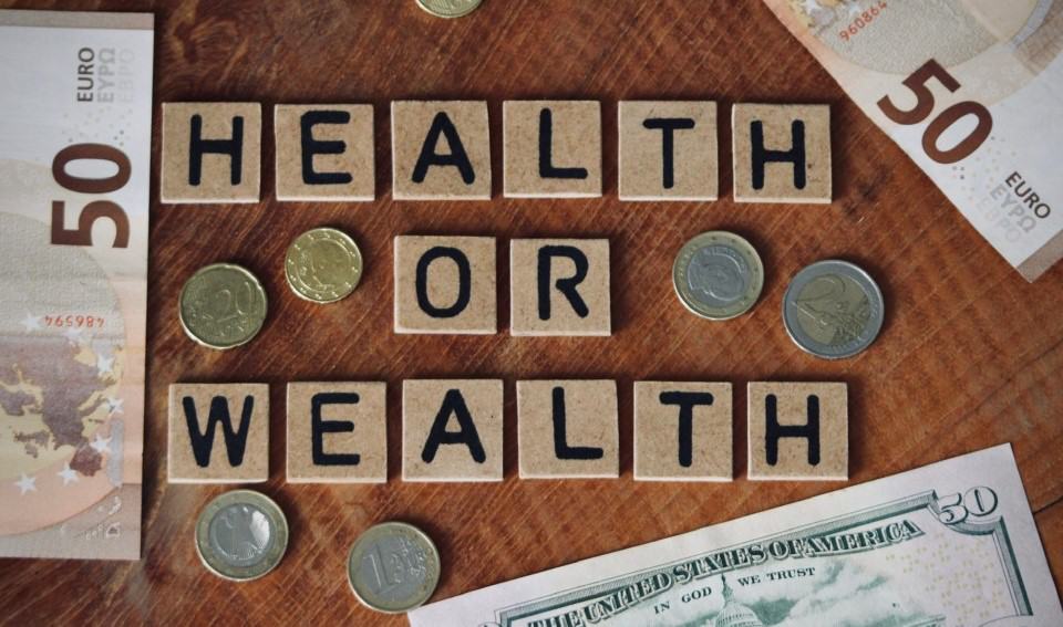Health or wealth , money , bills and coins , choices , flatlay , wooden blockletters , quote