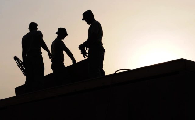 Silhouette of workers on a roof