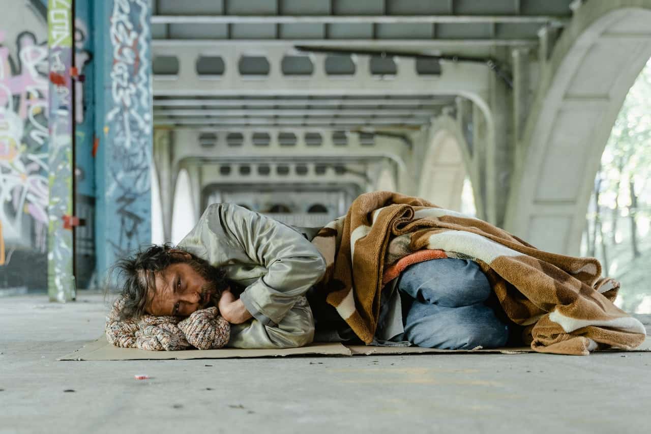 Homeless guy laying down under an overpass