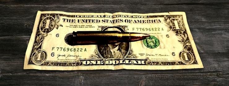 bullet sitting on top of a dollar bill
